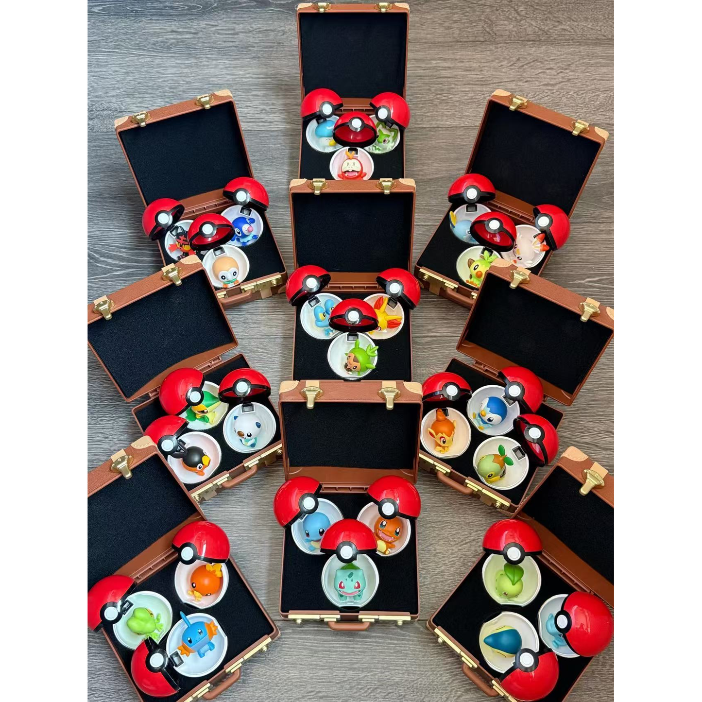 
All nine Pokémon First Partner suitcases opened to show 27 regional starter mini figures