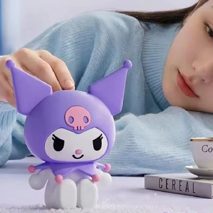 A small Kuromi figurine made of soft purple silicone is shown in a lifestyle setting, with a woman in a light blue sweater touching it. The image includes promotional text for 'Kuromi' and 'Ali Fish' on a light background.